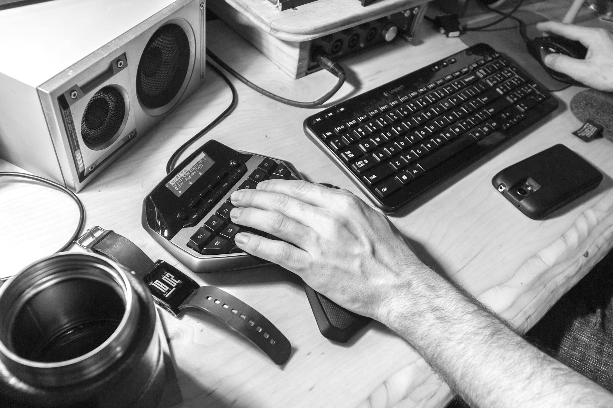 Black and white photo of a modern workspace with various tech gadgets and peripherals.