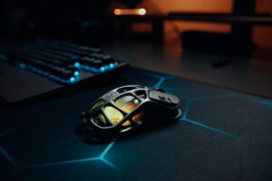 High-tech lightweight gaming mouse glowing on a sleek RGB illuminated desk setup.